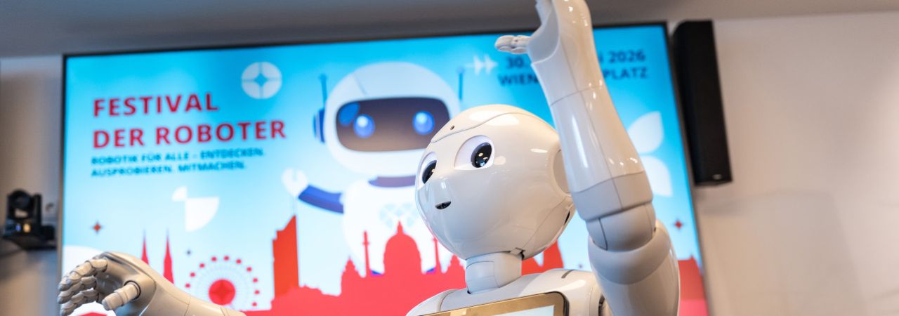Kleiner Roboter vor dem Festival-Sujet