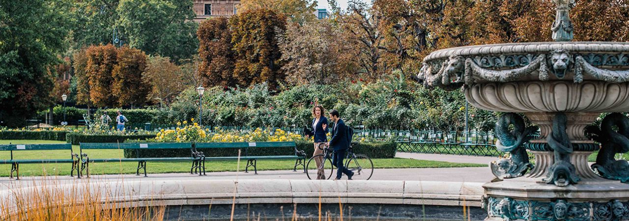 A Man and a Woman are walking through a park in Vienna